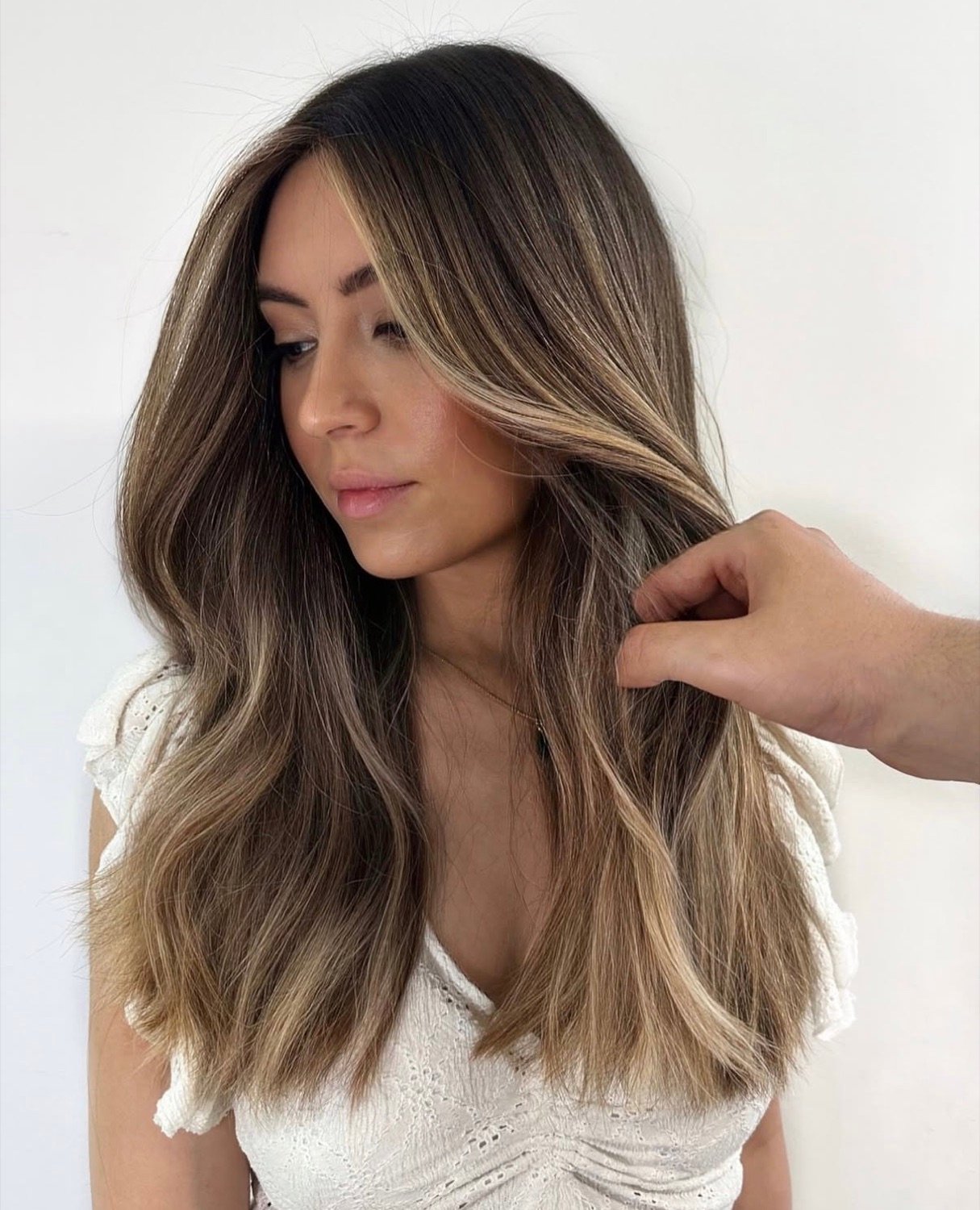 Brunette balayage with soft blonde face-framing pieces